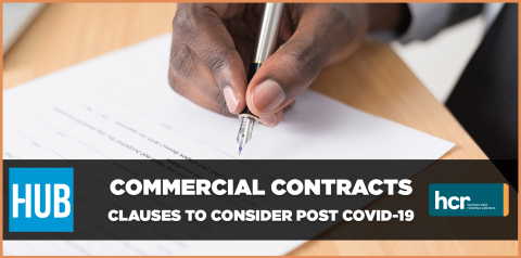 A hand is pictured signing a contract.